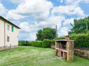 una chimenea al aire libre en el patio de una casa en Aesthetic Farmhouse in Bucine with Barbecue, en Bucine