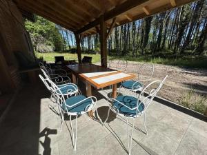 un tavolo e sedie in legno su un patio di La resiniere a Magescq