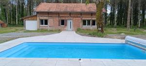 una casa con piscina di fronte a una casa di La resiniere a Magescq