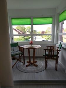 a table and chairs in a room with windows at Windspiel in Schönberg