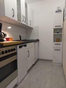 a kitchen with white cabinets and a stove at Windspiel in Schönberg