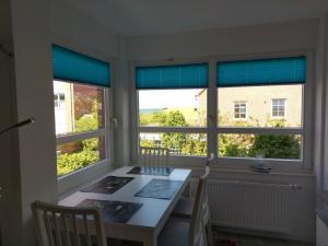 a dining room with a table and two windows at Windspiel in Schönberg