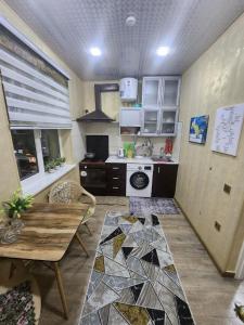 een keuken met een tafel en een keuken met een fornuis bij Sergeli apartment in Sergeli