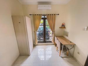 a room with a desk and a window with a computer at Avana Guesthouse in Kalasan