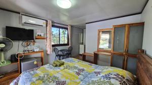 a bedroom with a bed and a tv and windows at One khaokho homestay in Khao Kho