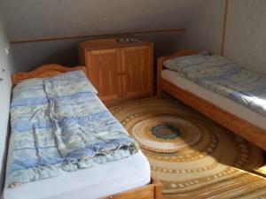 a bedroom with two beds and a wooden cabinet at Bábakalács in Fony