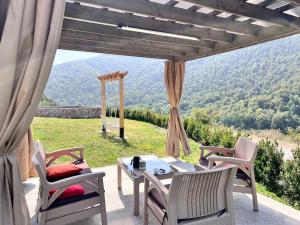 a patio with a table and chairs and a view at Green Villa Resort White in Dilijan