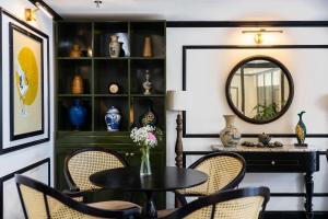 a dining room with a table and chairs and a mirror at Cherry Đà Lạt 3 - Luxury Hotel in Da Lat