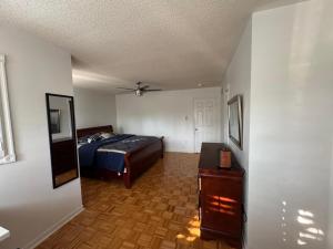 a bedroom with a bed and a wooden floor at Pearson Gateway Comfort Home in Mississauga