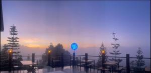 a restaurant with tables and a blue sign on a balcony at One khaokho homestay in Khao Kho