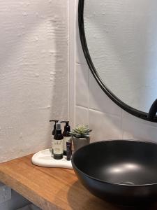 een badkamer met een zwarte wastafel en een spiegel bij Courtyard Pool Studio Private Luxe Retreat in Coal Point