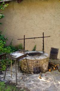 an outdoor grill with a table next to a wall at Bábakalács in Fony