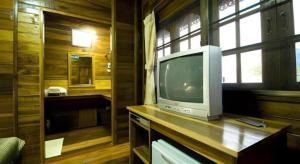 ein Fernseher, der auf einer Holztheke in einem Raum steht in der Unterkunft Little Home Beach in Ban Khok Rak