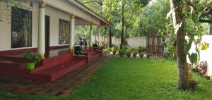 a patio of a house with a grass yard at sea scape homestay in Mararikulam