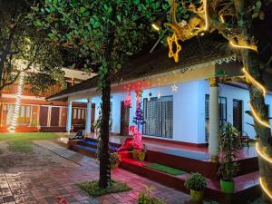 a house with a tree in front of it at sea scape homestay in Mararikulam +8 photos
