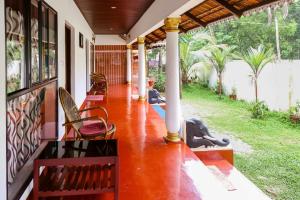a porch of a house with benches on it at sea scape homestay in Mararikulam