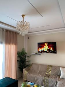 een woonkamer met een kroonluchter en een bank bij Villa Sabrina in Awlād ‘Umar +36 foto's