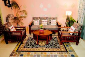 a living room with a couch and two chairs and a table at The Gulmohar Villa in Tājganj