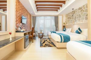 a hotel room with two beds and a kitchen at Tulsi Kathmandu Hotel in Kathmandu