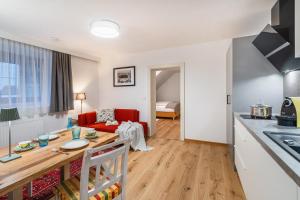 una cucina e un soggiorno con un tavolo e un divano di Das Landhaus Apartments Prägant a Bad Kleinkirchheim