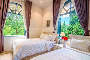 ein Schlafzimmer mit zwei Betten und einem Fenster in der Unterkunft Chu Mansion - Chill & Grill and Pickeball in Da Thien