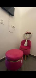 Una otomana roja y una silla roja en una habitación. en Mayank Residency, en Amritsar