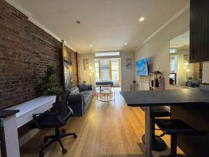 un soggiorno con un divano e un muro di mattoni di Midtown Prestige a New York