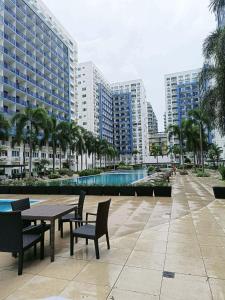 eine Terrasse mit Tisch und Stühlen und Gebäuden in der Unterkunft Sea Residences Wonders in Manila