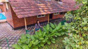 een vrouw staat voor een huis bij Sylora Meadows Private Pool Villa ,Vagamon in Pīrmed +40 foto's