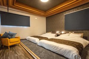 a hotel room with two beds and a large screen at Pine21 TOHOKU 