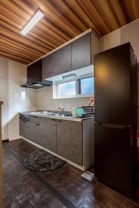a kitchen with a black refrigerator and a sink at Pine21 TOHOKU 