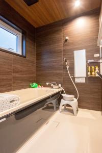 a bathroom with a tub and a toilet in it at Pine21 TOHOKU 