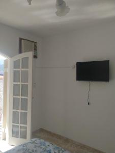 a bedroom with a flat screen tv on the wall at Novo Encanto in Ubatuba +20 photos