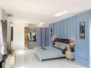 a bedroom with a bed and a blue wall at 3BR Pool Villa Beach Access Patumnak Hill in Pattaya South