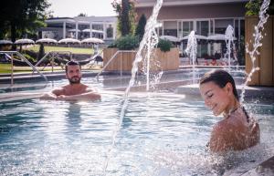 a man and a girl playing in a fountain at Hotel Mioni Pezzato in Abano Terme