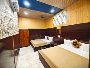 een kamer met 2 bedden en een tv. bij HOTEL OM PALACE NEAR MAHAKALESHWAR TEMPlE in Ujjain