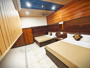 een hotelkamer met twee bedden en een bureau bij HOTEL OM PALACE NEAR MAHAKALESHWAR TEMPlE in Ujjain