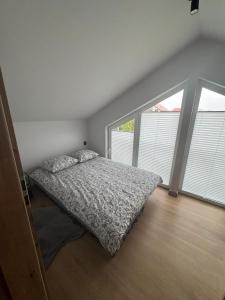 een slaapkamer met een bed en een groot raam bij TINY HOUSE domek do wynajęcia in Olsztyn