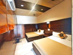 een hotelkamer met twee bedden en een bureau bij HOTEL OM PALACE NEAR MAHAKALESHWAR TEMPlE in Ujjain +14 foto's