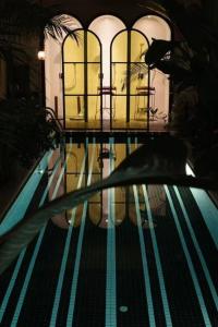 a reflection of a woman in a swimming pool at Grey Parrot Resort Hotel in Chengdu