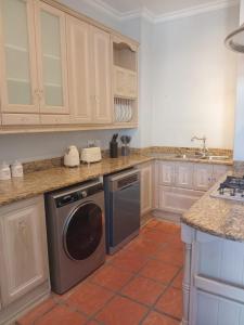 een keuken met witte kasten en een vaatwasser bij L'Ermitage Villa Francois in Franschhoek