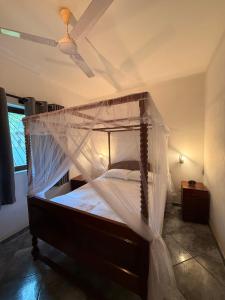 un letto con zanzariera in una stanza di Krishna Residence Ahangama ad Ahangama
