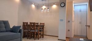 ein Wohnzimmer mit einem Tisch, Stühlen und einer Uhr in der Unterkunft Apartament Gdynia in Gdynia + 3 Fotos