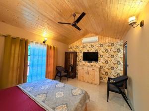 une chambre avec un lit et un ventilateur de plafond dans l'établissement Jolly Retreat, à Jhājra