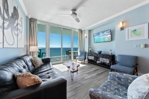 a living room with a couch and a tv at Lighthouse 714 in Gulf Shores
