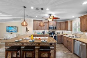 una cucina con armadi in legno e una grande isola con sgabelli da bar di Amazing Heated & Screen Pool w Stunning Design! a Palm Harbor