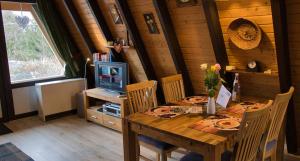 a dining room with a wooden table and a television at Haus Sternenblick 22 in Freyung