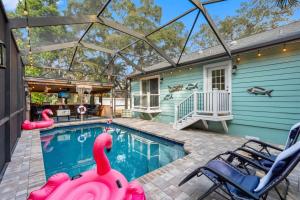 una piscina con cigni gonfiabili in una casa di Amazing Heated & Screen Pool w Stunning Design! a Palm Harbor