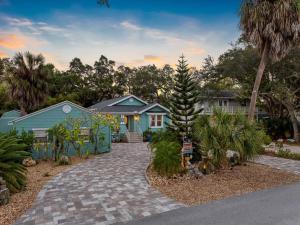 una casa con una palma di fronte a un vialetto di Amazing Heated & Screen Pool w Stunning Design! a Palm Harbor