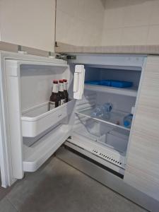 un frigorifero aperto con bottiglie di birra di Sant Antioco Yellow Apartment with 2 Way Air Con a SantʼAntìoco